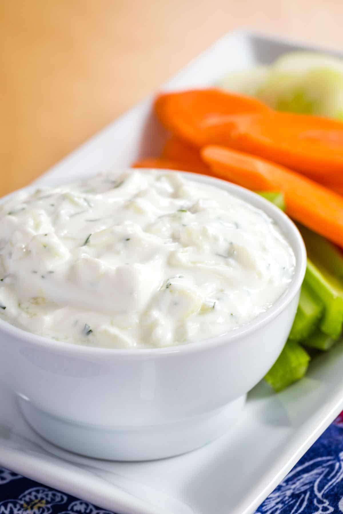 A closeup of a small white bowl of tzatziki sauce.